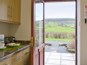 an open kitchen door with a view of the countryside at Beuchan Cottage Keir Mill in Closeburn