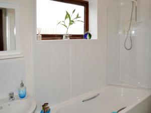 a bathroom with a tub and a sink and a window at Beuchan Cottage Keir Mill in Closeburn +9 photos