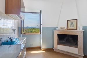 a kitchen with a fireplace and a window at Le Vallocchie in Concerviano