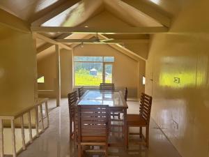 a dining room with a table and chairs and a window at Samoon Guest House in Karnāl