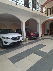 two cars are parked in a garage at Hostal CADENA casa de huéspedes in Sucre