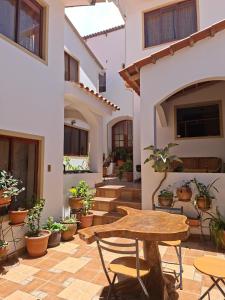 a patio with a table and chairs and potted plants at Hostal CADENA casa de huéspedes in Sucre