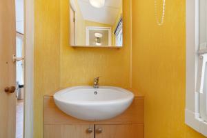 a bathroom with a white sink and a mirror at 23.Mobil-home option clim-5pers in Calviac +29 photos