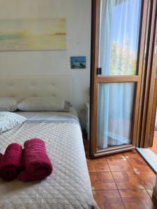 a bedroom with a bed with purple towels on it at La Vela Apartment in Stintino