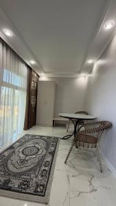 a room with a table and chairs and a rug at Comfort Point Hotel in Bishkek