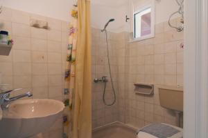 a bathroom with a shower and a sink and a toilet at Lisipio Studios by Eleni in Paleokastritsa +86 photos