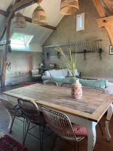 a large wooden table with chairs and a vase on it at Le maison sour les ailes in Cossaye +32 photos
