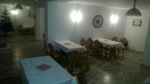 a dining room with tables and chairs and a clock on the wall at Willa Cachro in Zakopane
