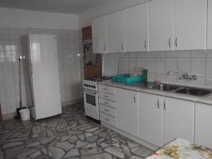 a kitchen with white cabinets and a white refrigerator at Willa Cachro in Zakopane