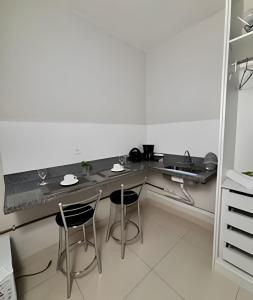a kitchen with a table and two chairs at Studio #3 Rubi in Campos dos Goytacazes