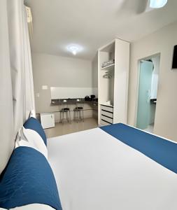 a person sitting on a bed in a bedroom at Studio #3 Rubi in Campos dos Goytacazes +3 photos