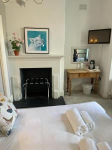 a bedroom with a bed and a desk and a fireplace at Poplars Farm in Henlow