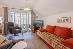 a living room with a couch and a television at Seeblick Leuchtturm in Koserow
