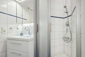 a white bathroom with a sink and a shower at Seeblick Leuchtturm in Koserow