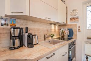 a kitchen with a sink and a coffee maker on a counter at Seeblick Leuchtturm in Koserow +22 photos