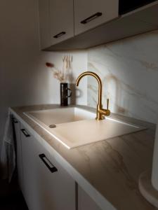 a white kitchen sink with a gold faucet at Villa Loka-Ecrin contemporain Adult only in Sauzet +25 photos