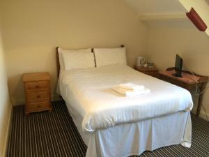 a bedroom with a bed and a tv on a table at Lockyer House B&B in Plymouth