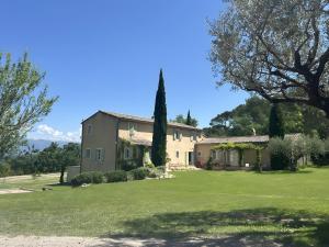 a house with a large yard with green grass at Au Clair Ventoux in Saint-Didier