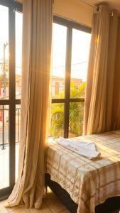a bedroom with a bed and a large window at Pousada Rotamar in Paraipaba