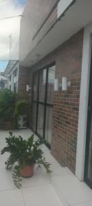 a brick building with potted plants in front of it at Pousada Rotamar in Paraipaba