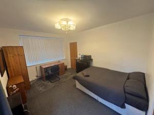 a bedroom with a bed and a desk and a window at Studio sleeps 2 with Parking in Derby