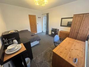 a bedroom with a bed and a desk and a table at Studio sleeps 2 with Parking in Derby