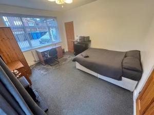 a bedroom with a bed and a desk and a window at Studio sleeps 2 with Parking in Derby +3 photos