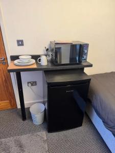 a microwave sitting on a table next to a bed at Studio sleeps 2 with Parking in Derby