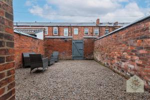 a brick alley with benches in front of a building at Fairhurst House in Leigh +2 photos