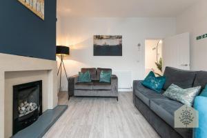 a living room with a couch and a fireplace at Fairhurst House in Leigh