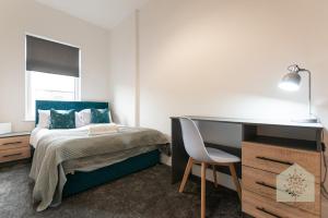 a bedroom with a bed and a desk and a chair at Fairhurst House in Leigh