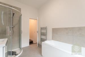 a bathroom with a shower and a bath tub at Fairhurst House in Leigh