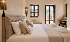 a bedroom with a large white bed with pillows at Areos Polis Boutique Hotel in Areopoli
