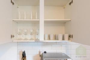 a kitchen with glasses on shelves and a counter at Holt House in Hindley