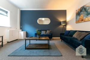 a living room with a blue couch and a table at Holt House in Hindley
