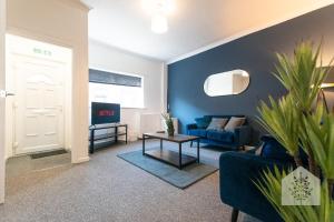 a living room with a blue couch and a table at Holt House in Hindley