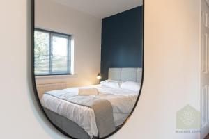 a mirror reflection of a bed in a bedroom at Holt House in Hindley