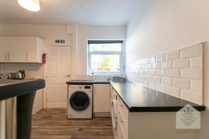 a kitchen with a washer and dryer on a counter at Holt House in Hindley +2 photos