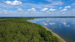 an aerial view of a lake with trees and water at Natura Ferienpark - Bungalows am Grimnitzsee Schorfheide in Althüttendorf +69 photos
