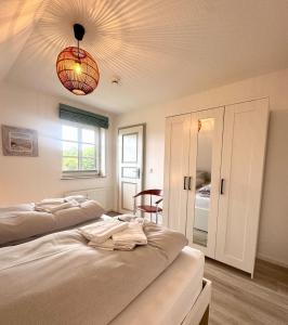 a bedroom with two beds and a chandelier at Inselglück Föhr in Wrixum +14 photos