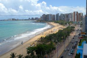 uma vista para uma praia com edifícios e o oceano em Bourbon Fortaleza Hotel Beira Mar em Fortaleza