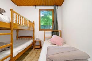 a bedroom with two bunk beds and a window at 17.Les Etoiles option Clim- 7 pers in Calviac