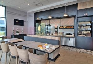 a restaurant with a table and chairs and a counter at B&B HOTEL Dreux Nord in Dreux