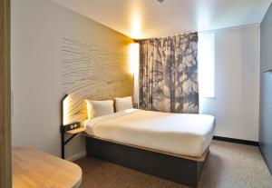 a hotel room with a bed and a window at B&B HOTEL Dreux Nord in Dreux