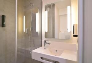 a white bathroom with a sink and a shower at B&B HOTEL Dreux Nord in Dreux