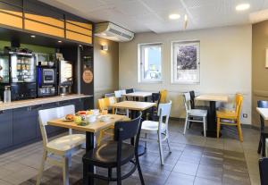 a restaurant with tables and chairs and a counter at B&B HOTEL Dijon Les Portes du Sud in Marsannay-la-Côte