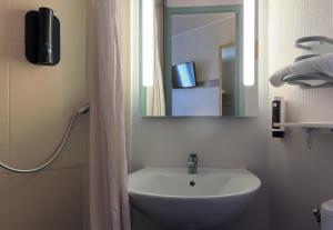 a bathroom with a sink and a mirror at B&B HOTEL Dijon Les Portes du Sud in Marsannay-la-Côte