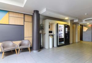 a lobby with two chairs and a column in a building at B&B HOTEL Dijon Les Portes du Sud in Marsannay-la-Côte
