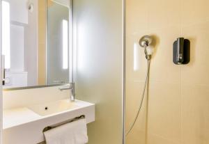 a bathroom with a shower with a sink and a mirror at B&B HOTEL Montpellier Centre Le Millénaire 3 étoiles in Montpellier
