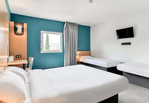 a bedroom with a white bed and a blue wall at B&B HOTEL Montpellier Centre Le Millénaire 3 étoiles in Montpellier